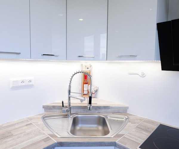 Modern kitchen sink with white cabinets and countertop